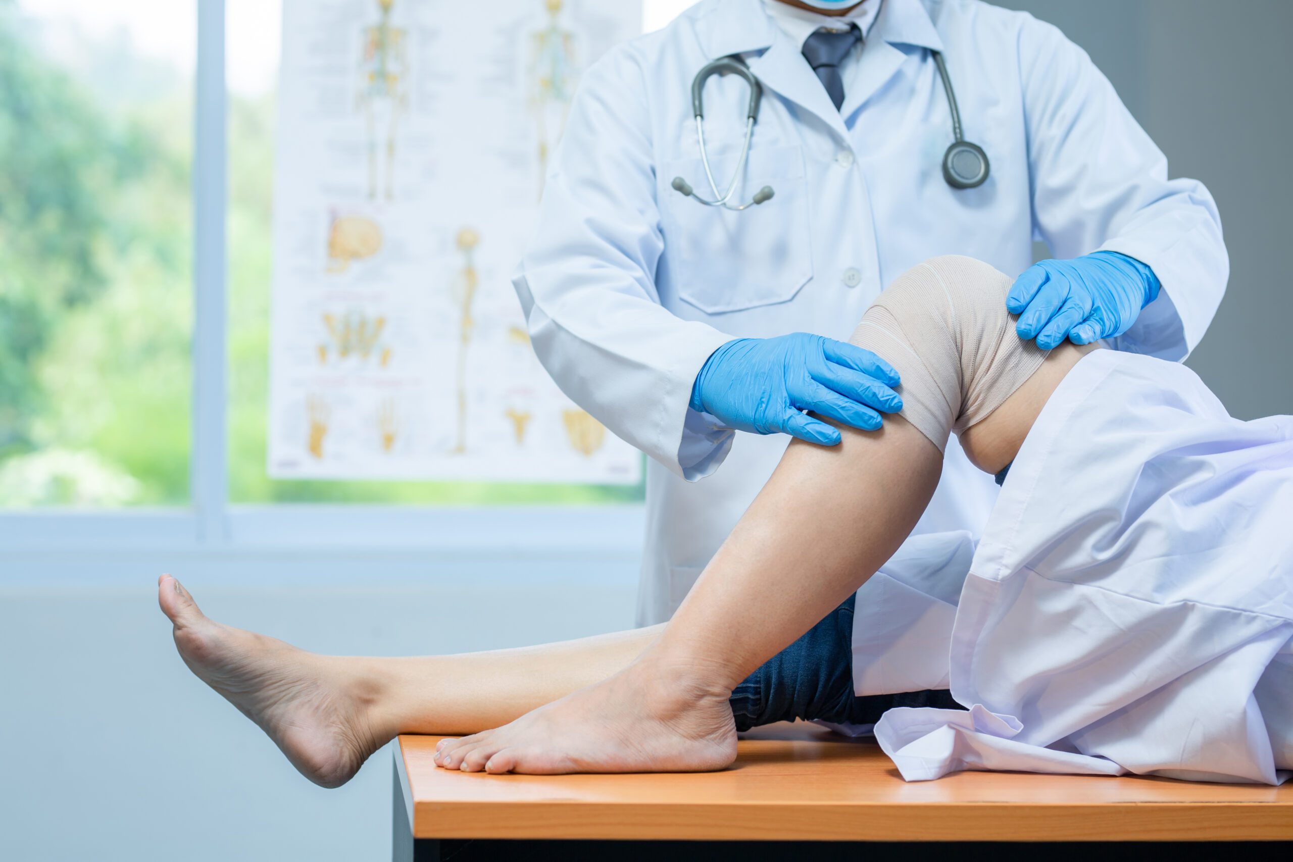 Doctor applying compression dressing to patient's knee