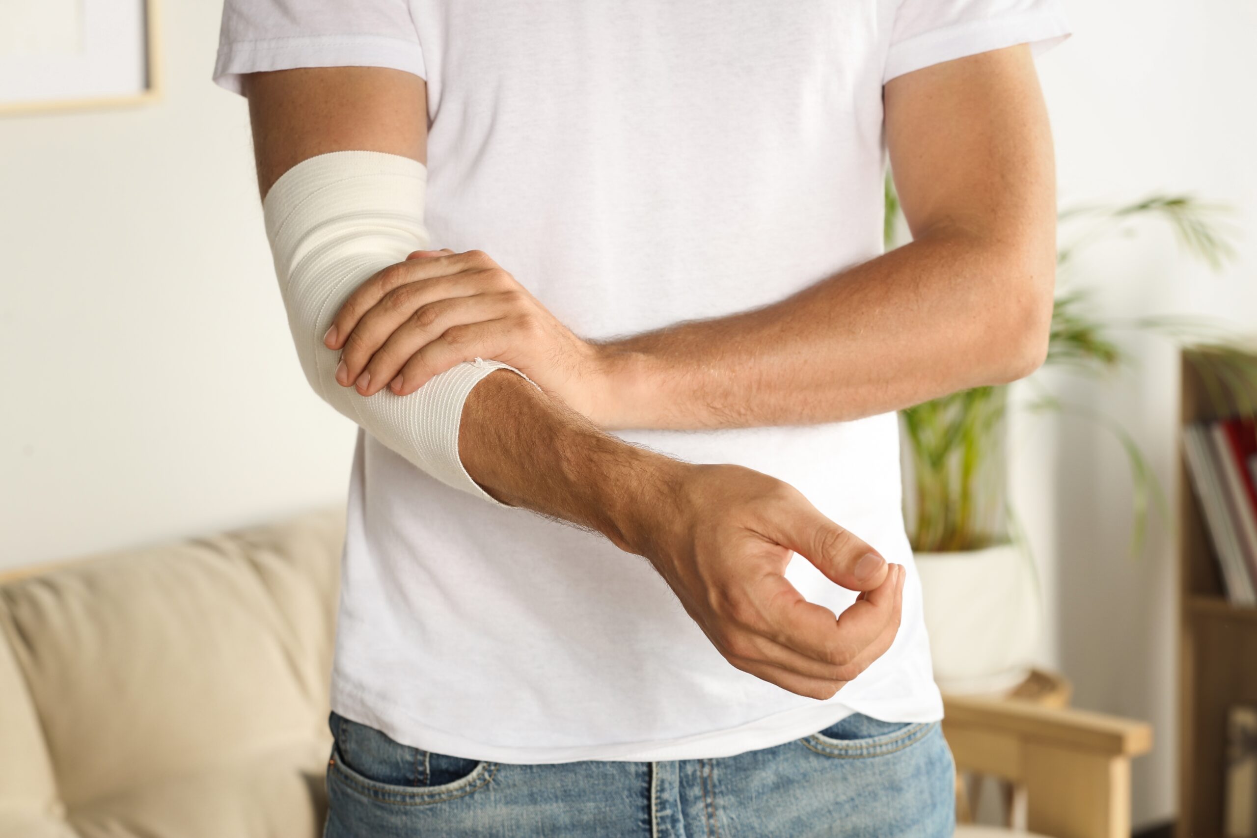 Man,With,Arm,Wrapped,In,Medical,Bandage,Indoors,,Closeup