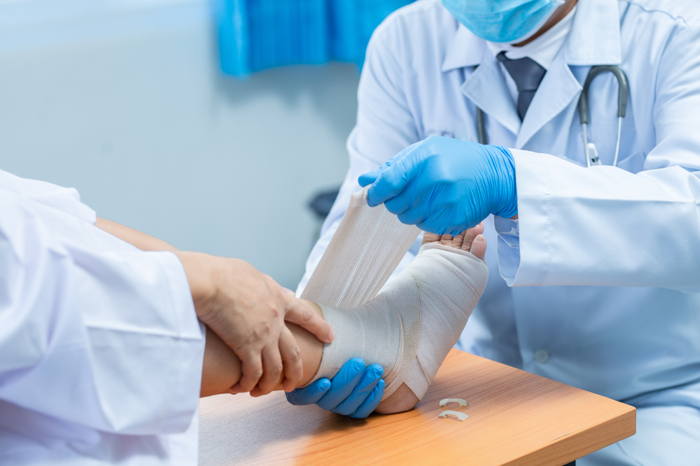 doctor examining patient's wounded foot