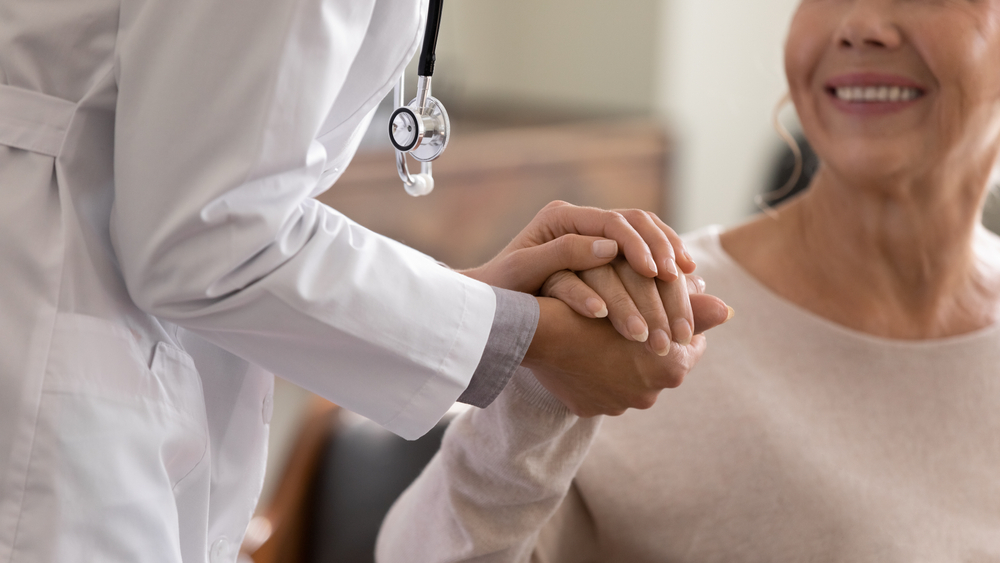 Doctor holding patient's hand.