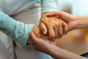 Doctor holding hands with elderly patient.