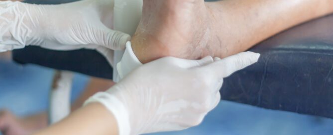 Doctor Applying Bandage to patient's foot.