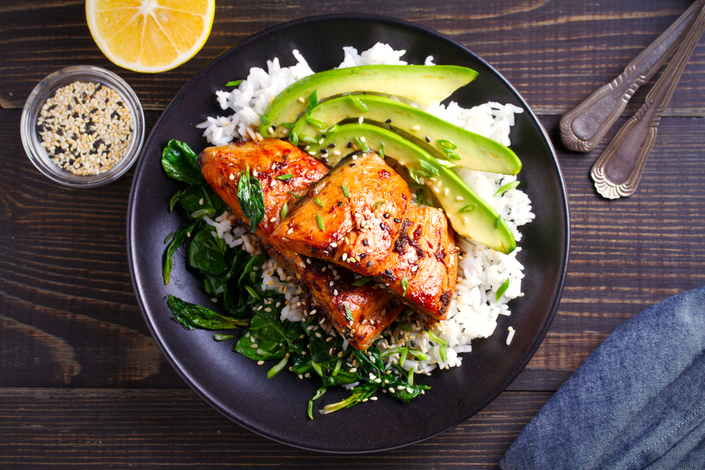 A teriyaki chicken bowl with avocado and rice.