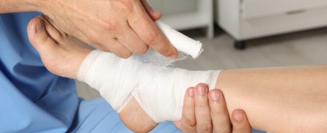 A doctor wrapping gauze around a foot.