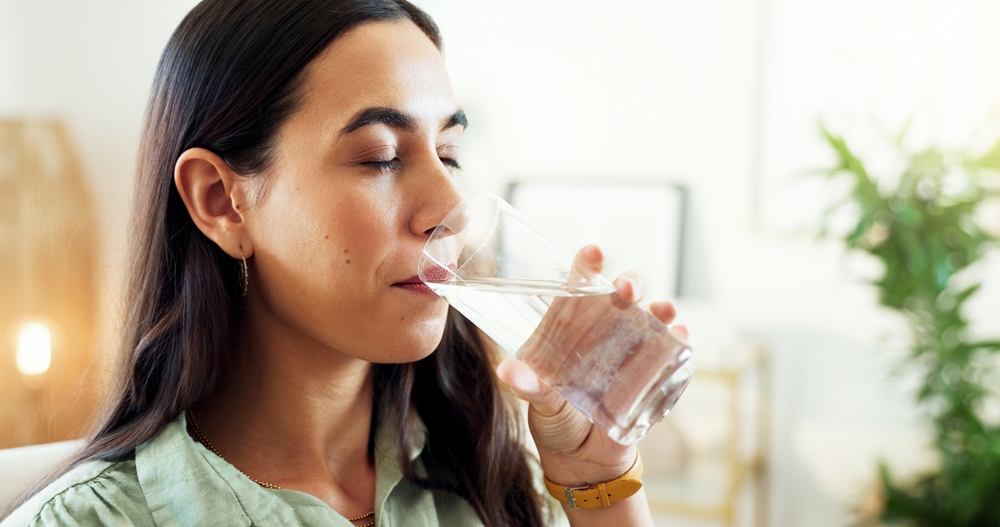 A woman drinking a glass of water.