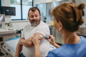 A doctor applying an insulin pump to a patient