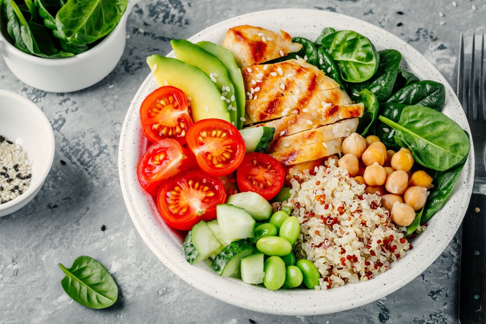 A bowl of quinoa, chicken, and veggies.