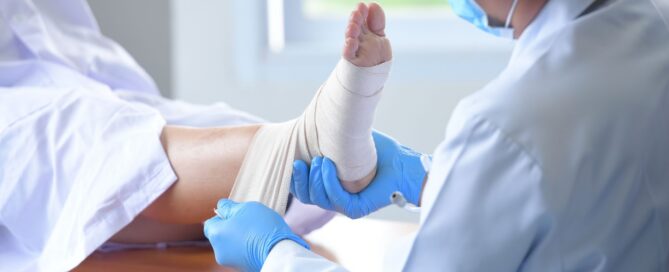 Clinician bandaging a patient’s foot with a wound dressing
